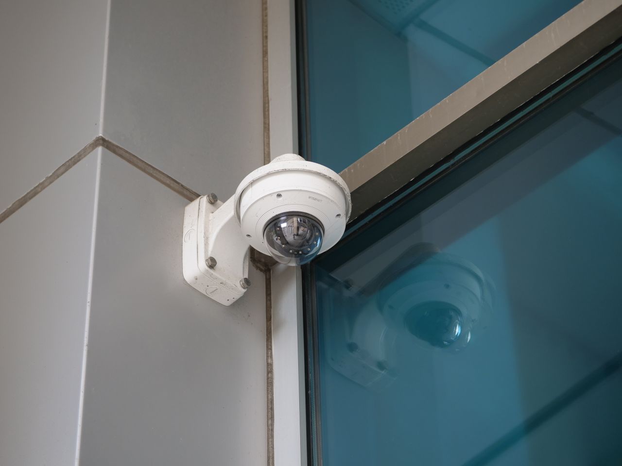 Security camera mounted on a building corner for surveillance and safety.